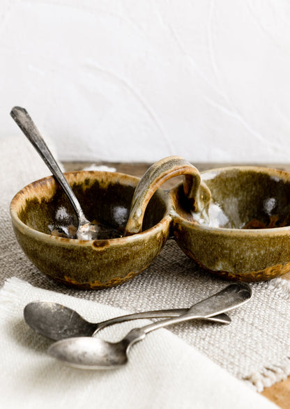 A double cellar ceramic vessel in variegated brown glaze.