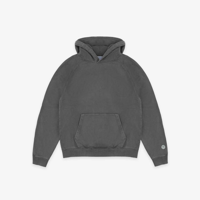 A dark gray washed cotton hoodie with a front kangaroo pocket and a small circular logo on the left sleeve cuff, displayed flat against a light gray background.