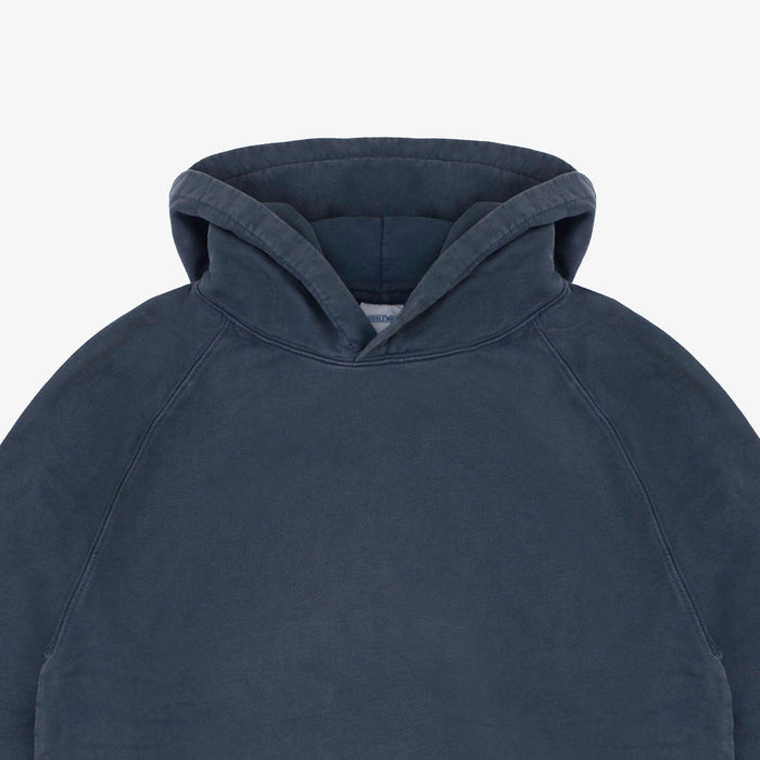Close-up of a dark slate blue hooded sweatshirt showing the hood and upper chest area against a light gray background.