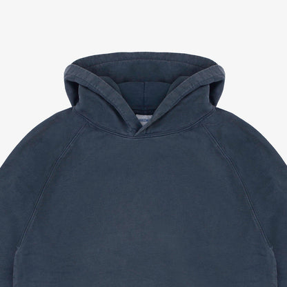 Close-up of a dark slate blue hooded sweatshirt showing the hood and upper chest area against a light gray background.