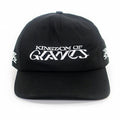 A black five-panel snapback hat from Kingdom Of Giants, featuring white embroidered text on the front that reads KINGDOM OF GRAVES. This adjustable cotton hat also has white embroidered symbols on both sides.