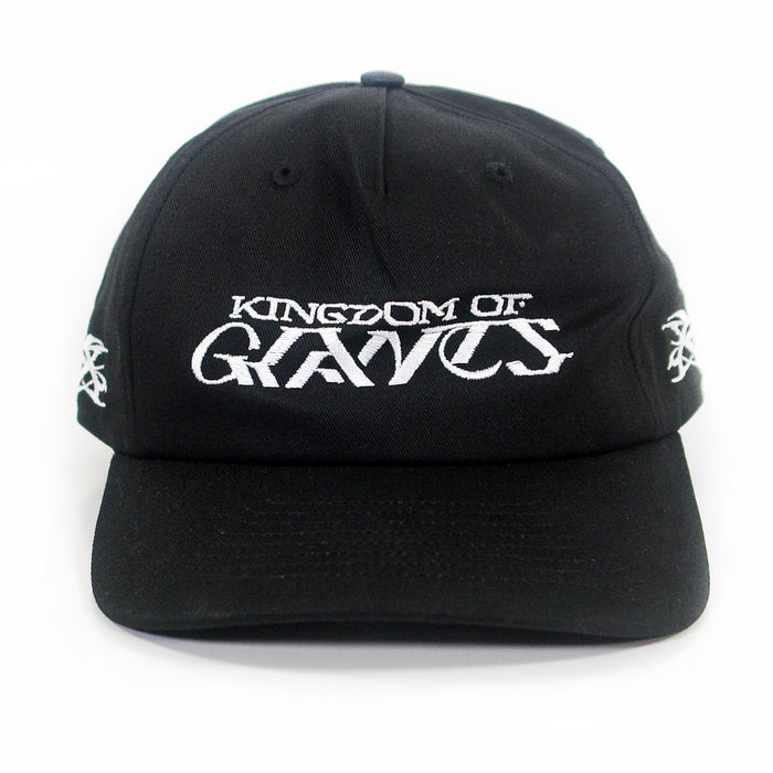 A black five-panel snapback hat from Kingdom Of Giants, featuring white embroidered text on the front that reads KINGDOM OF GRAVES. This adjustable cotton hat also has white embroidered symbols on both sides.