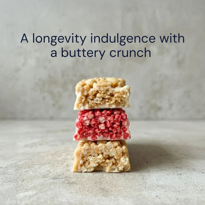 Three macadamia bars stacked on a textured surface with text 'A longevity indulgence with a buttery crunch'.