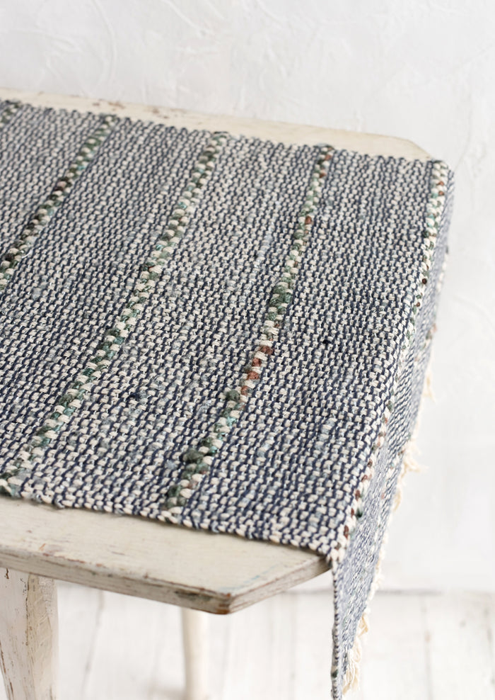 A blue and green table runner with stripe detail.