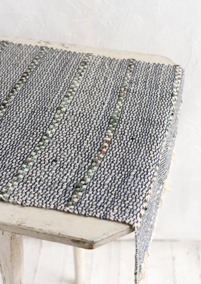 A blue and green table runner with stripe detail.