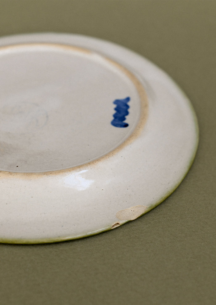 A pair of floral and squiggle painted plates in green, blue and orange.