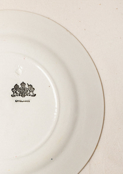 A pair of white plates with blue and red floral pattern around rim.