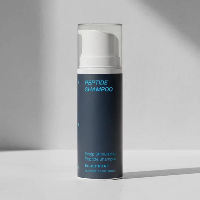 Peptide shampoo bottle with white cap on a gray background